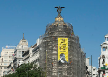 Activistas de Greenpeace cuelgan una pancarta en el edificio Metrópolis de Madrid para pedir a Obama que pare el TTIP
