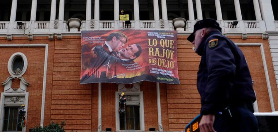 Greenpeace cuelga en la Gran Vía de Madrid un gran cartel de cine con Rajoy y el ministro Nadal de protagonistas para denunciar la política energética del Gobierno