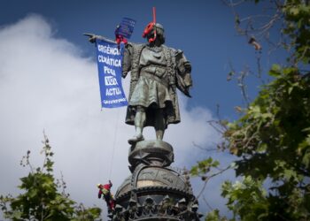 Activistas de Greenpeace denuncian en la estatua de Colón de Barcelona la indiferencia política frente a la crisis climática durante la campaña electoral