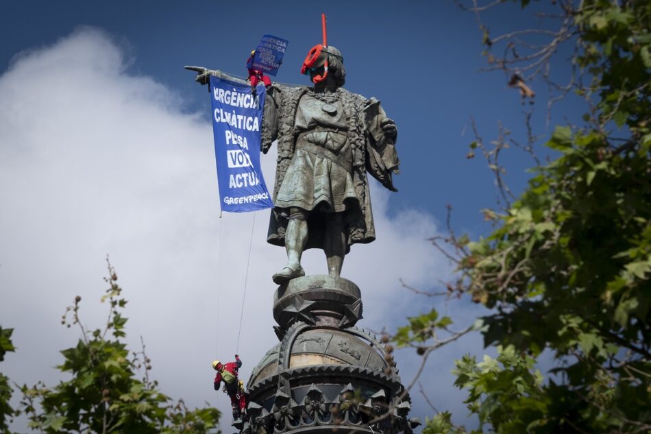 Activistas de Greenpeace denuncian en la estatua de Colón de Barcelona la indiferencia política frente a la crisis climática durante la campaña electoral