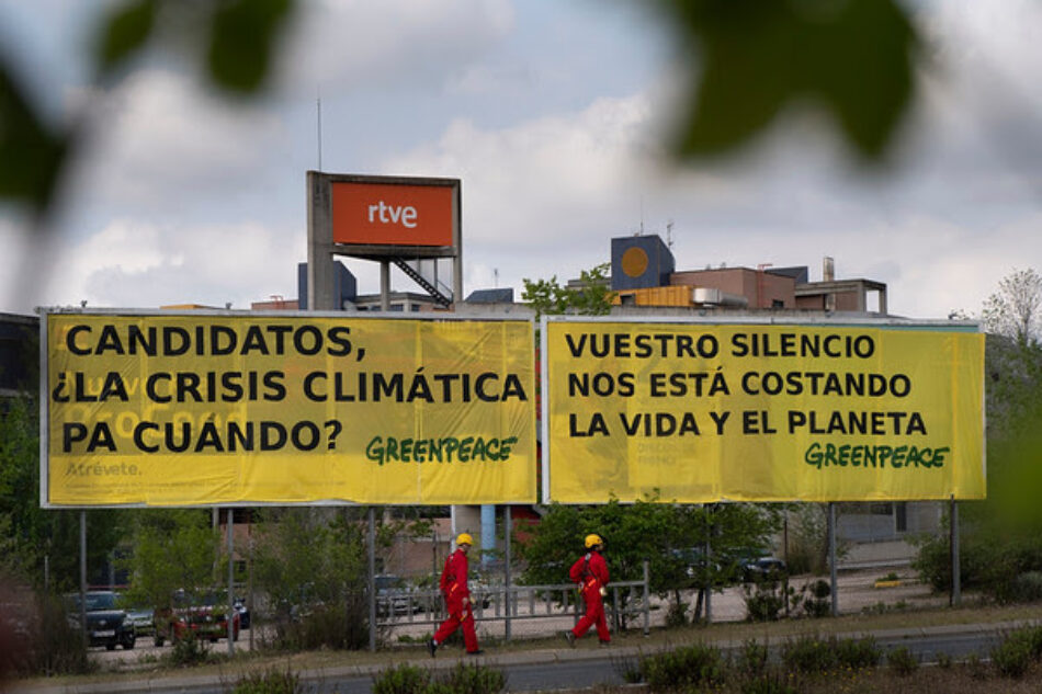 Activistas de Greenpeace cuelgan antes del debate de RTVE una pancarta para reclamar a los candidatos atención sobre la crisis climática