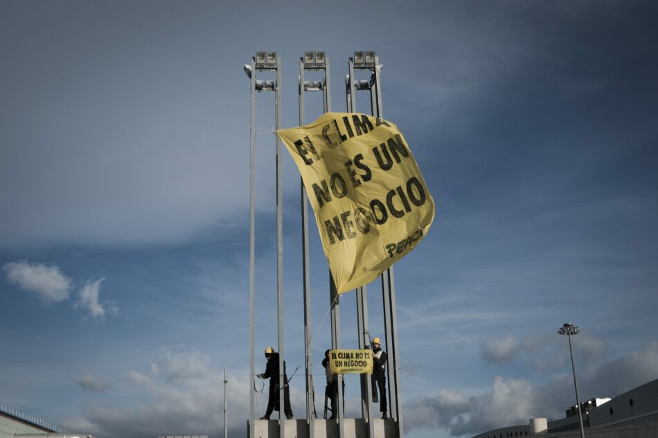 Escaladores de Greenpeace cuelgan pancartas frente a la COP para pedir un acuerdo justo y que no se negocie con el clima