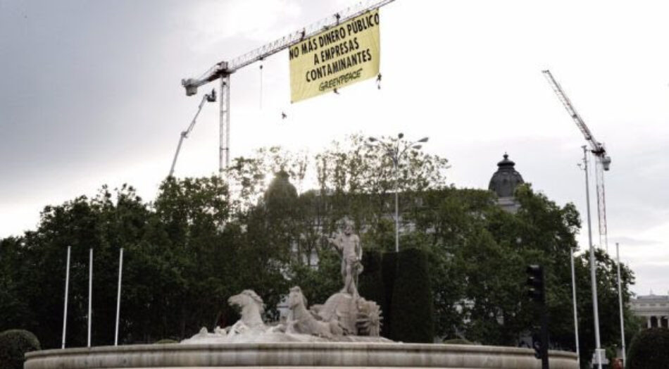 Escaladores de Greenpeace despliegan una pancarta junto al Congreso para exigir que no se destine más dinero público a empresas contaminantes